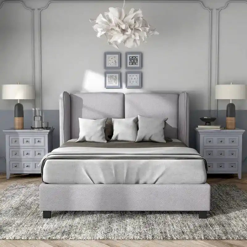Lit plateforme moderne grand format en tissu résilient, avec tête de lit capitonnée à oreilles.