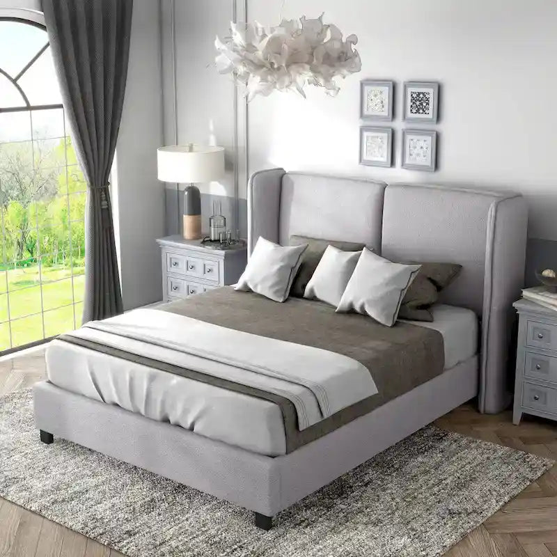 Lit plateforme moderne grand format en tissu résilient, avec tête de lit capitonnée à oreilles.