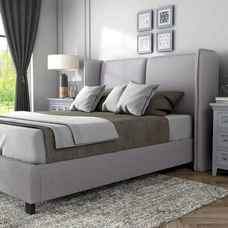 Lit plateforme moderne grand format en tissu résilient, avec tête de lit capitonnée à oreilles.